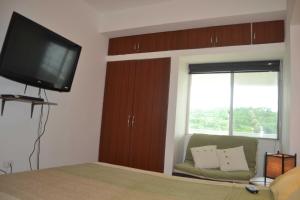 - une chambre avec un lit et une télévision à écran plat dans l'établissement Suite frente al mar Playa Azul, à Tonsupa