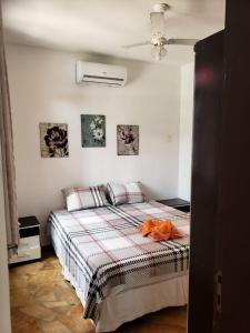 a bedroom with a bed with an orange robe on it at Paraiso de Maracajau 1 in Maracajaú