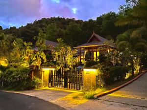 a house with a gate on a street at night at The Sanctuary Langkawi in Pantai Cenang