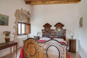 a bedroom with a large wooden bed in a room at Masseria Storica Pilapalucci in Toritto +11 photos