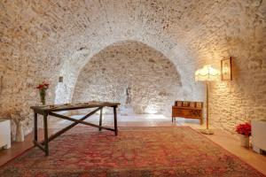 a room with a table and a stone wall at Masseria Storica Pilapalucci in Toritto
