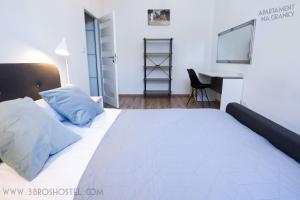 a bedroom with a white bed and a desk at Apartament na Granicy / Apartment on the border in Cieszyn