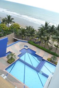 - une vue sur la piscine et la plage dans l'établissement Suite frente al mar Playa Azul, à Tonsupa