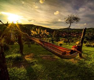 a man sitting in a hammock in a field at Hostel Serena in Samaipata