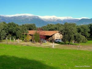 une maison dans un champ avec des montagnes en arrière-plan dans l'établissement Casa Rural El Roblon, à Sartajada