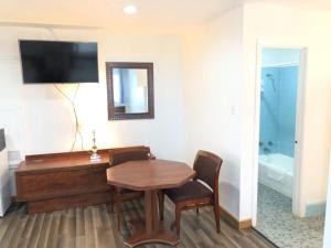 a room with a table and a television and a bathroom at Gulfway Motel and Restaurant in Gilchrist