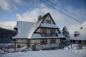 a house covered in snow with a ski lift at uDany in Brzegi