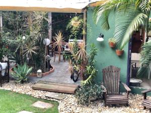 a patio with chairs and plants and a green wall at Pousada Santarina in Florianópolis