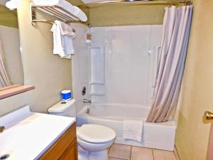 a bathroom with a toilet and a tub and a sink at Americas Best Value Inn & Suites Anchorage Airport in Anchorage