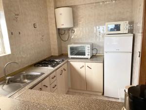 cocina con nevera blanca y microondas en Sun and Beach lovers, Apartment 14139, La Pineda, en La Pineda