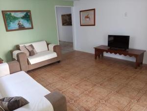 a living room with a couch and a table at Casa Rosarinho 1- RECIFE - Quartos com Banheiros Exclusivos in Recife