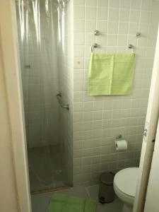 uma casa de banho com um chuveiro e um WC com uma toalha em Casa Rosarinho 1- RECIFE - Quartos com Banheiros Exclusivos no Recife