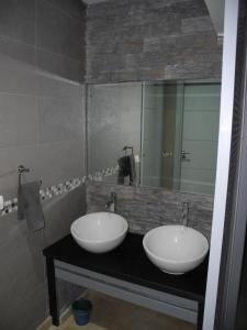 Chalet Mirleft في ميرلفت: حمام مغسلتين ومرآة