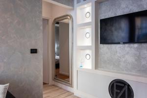 a living room with a television and a mirror at FASHION APARTMENT SILVER Bologna in Bologna