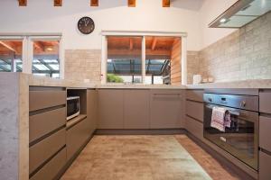 a kitchen with brown cabinets and a clock on the wall at Port Central No 3 in Port Campbell