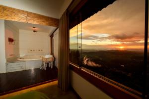 a bathroom with a tub and a window with a view at Pousada Estalagem do Mirante in Brumadinho +37 photos
