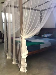 uma cama de dossel e cortinas num quarto em Disa Residence em Galle