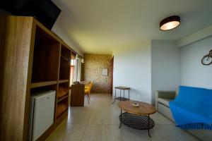 a living room with a blue couch and a table at Pousada Estalagem do Mirante in Brumadinho