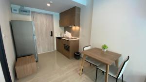 um pequeno apartamento com uma mesa e uma pequena cozinha em La Casita pool access condo HuaHin em Hua Hin
