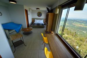 a bedroom with a bed and a large window at Pousada Estalagem do Mirante in Brumadinho