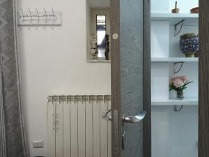 una puerta en una habitación con radiador y espejo en Bed & Breakfast a Capua Adiacente al Duomo - IL VICOLO, en Capua