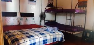 a bedroom with a bed and two bunk beds at Tajau Laut Guesthouse in Kudat