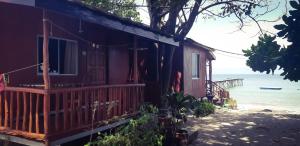 a house on the beach next to the ocean at Tajau Laut Guesthouse in Kudat
