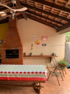 un patio con chimenea de ladrillo, mesa y sillas en Casa Da Tiete - Foz do Iguaçu - PR, en Foz do Iguaçu