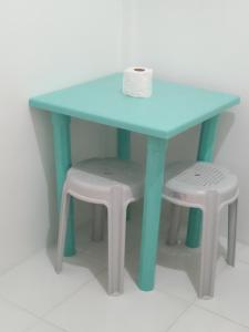 a blue table and two stools with a roll of toilet paper at Lapyahan Guest House in Siquijor
