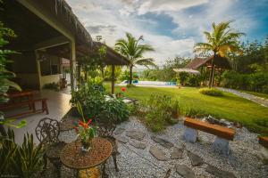 a backyard with a bench and a garden at Romantic Tropical Retreat with Sunset & Rice Field Views in Kuah