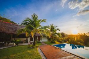 a villa with a swimming pool and a house at Alamanda Villas Langkawi in Kuah