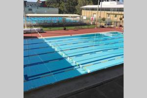 une grande piscine avec des couloirs bleus dans l'établissement B5 Crawley Apartment 1 BRM & Sleepout near UWA, à Perth