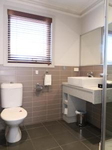 a white toilet sitting next to a sink in a bathroom at Seymours On Lydiard in Ballarat