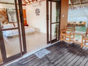a room with a bedroom and a bed and a porch at Chomjan Resort in Ko Phayam