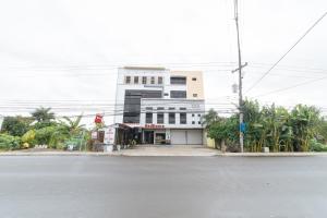 a white building on the side of a street at RedDoorz @ San Jose Tagbak Jaro Iloilo in Iloilo City