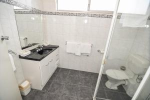
a bathroom with a toilet, sink, and bathtub at Dandenong Motel in Dandenong
