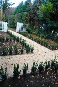 a garden with a white fence and some plants at B&B Le 36 in Brussels