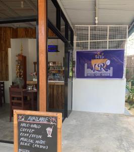 una cafetería con un cartel delante en LR Hostel and Cafe en Moalboal