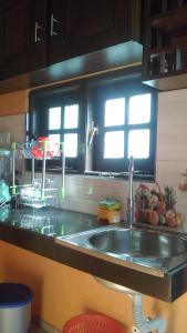 a kitchen counter with a sink and two windows at Sawanga Home Stay in Weligama