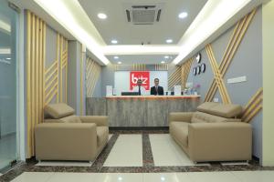 a lobby with two couches in front of a counter at Bitz Bintang Hotel in Kuala Lumpur