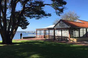 a man standing next to a building next to the water at B7 Crawley Apartment 1 BRM & Sleepout near UWA in Perth