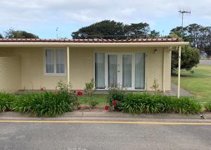 a yellow house with flowers in front of it at Relax On Bingham in Goolwa