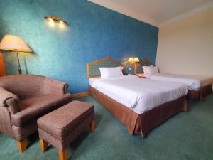 a hotel room with two beds and a chair at Parkview Hotel in Kampong Jerudong +37 photos