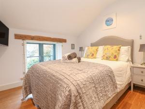 a bedroom with a large bed and a window at Lantern Cottage in Padstow