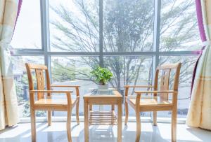 a table and two chairs in front of a window at RIO Hotel and Apartment in Vung Tau