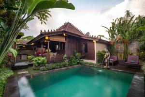 une villa avec une piscine en face d'une maison dans l'établissement Villa Nini, à Ubud