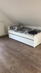 a white bed in a room with a floor at Hostel Nordkirchen by Frerichmann in Nordkirchen