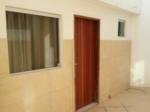 a red door in a room with a window at Viking Flat in Praia do Frances