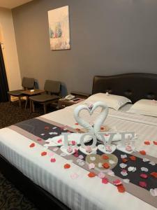 een hotelkamer met een bed met een hart gemaakt van liefdesproducten bij Greenlast Hotel in Kuantan