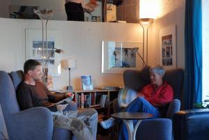 
a man and a woman sitting on a couch in a living room at Voss Vandrarheim Hostel in Vossevangen
